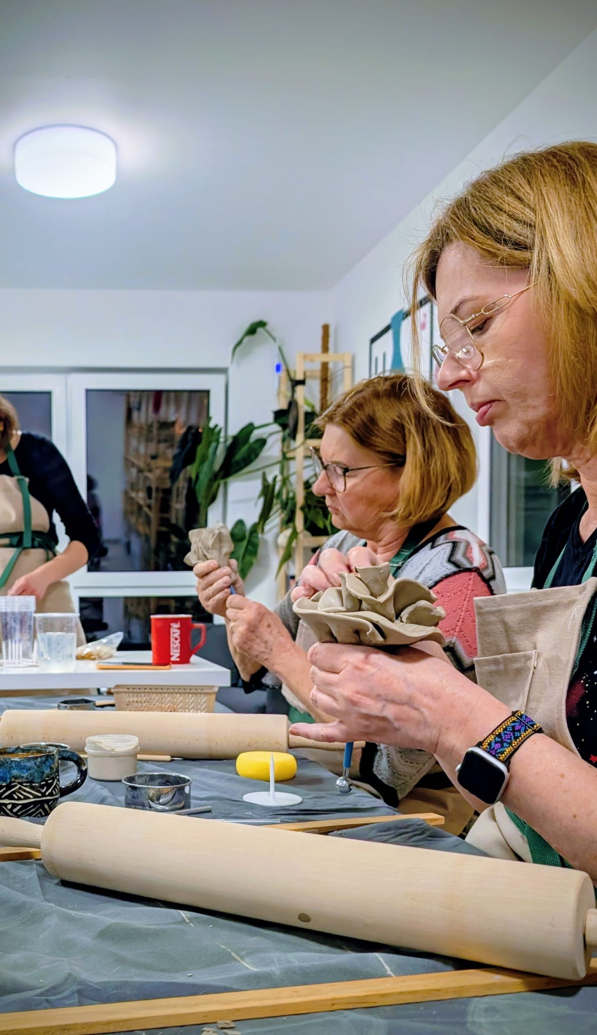 Uczestniczki skupione na formowaniu kwiatów ceramicznych
